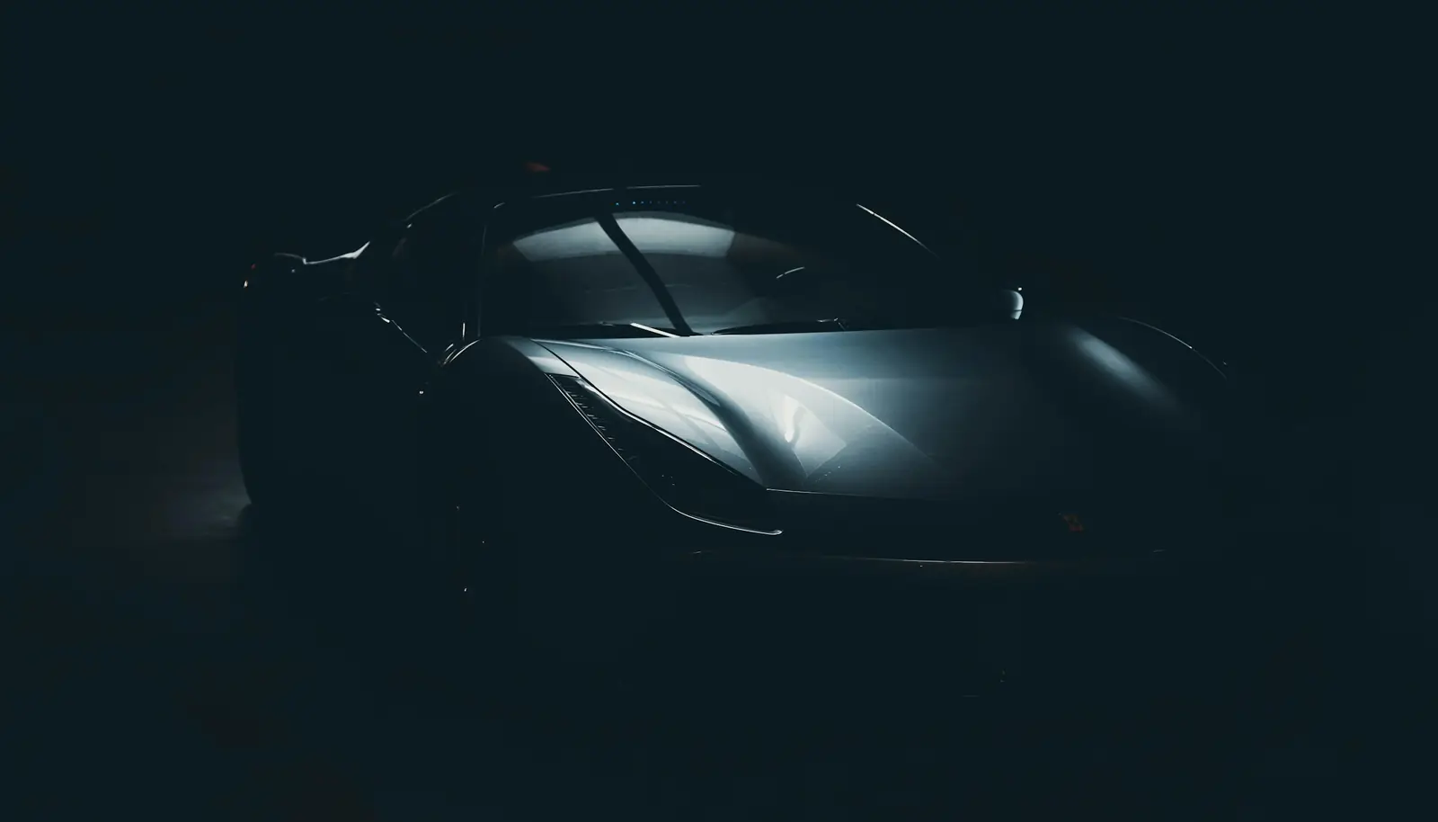 Carro esportivo escuro iluminado em estúdio